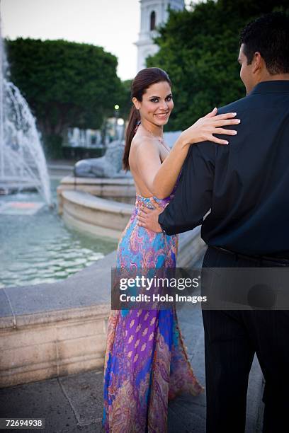 couple embracing by fountain in plaza, sunset - puerto rico dance stock pictures, royalty-free photos & images