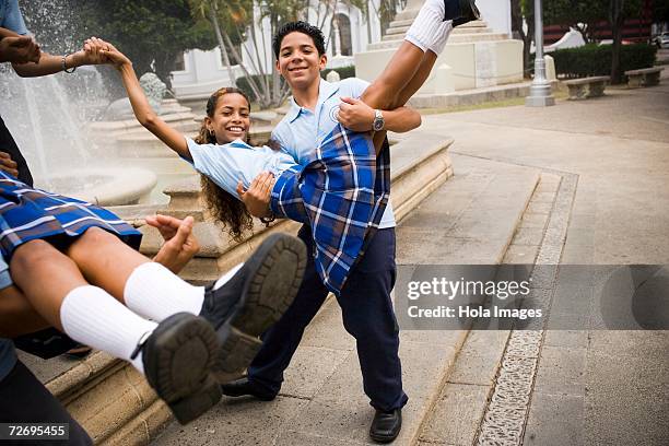 school boys carrying girls in center plaza - antilles stock pictures, royalty-free photos & images