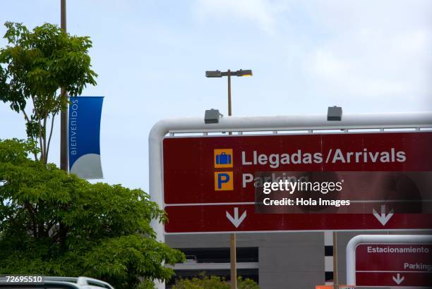 arrival airport sign, bilingual - punta lingua foto e immagini stock