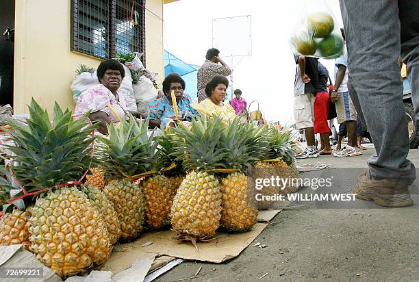 Two boys sit on a pile of pineapples as shopping continues as normal in central Suva after a deadline imposed by Fijian military commander Voreqe...