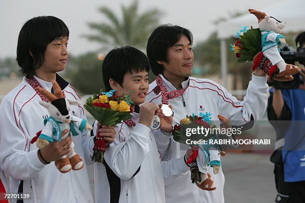 South Korea's men's 10m air rifle team silver winners Jaechul Yu, Kean Bae Chae and Hyesung Kim stand on the winner's podium 15th Asian Games Doha...