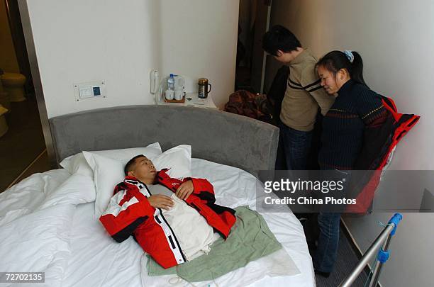 Peng Shuilin chats with his wife and son at a hotel December 2, 2006 in Beijing, China. Peng Shuilin was hit by a freight truck in a traffic accident...