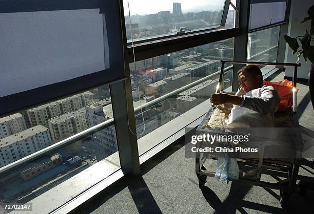 Peng Shuilin looks over a catheter December 2, 2006 in Beijing, China. Peng Shuilin was hit by a freight truck in a traffic accident in 2004 and his...