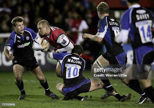Mike Tindall, Captain of Gloucester is tackled by Tom Cheeseman and Chris Malone, Captain of Bath during the EDF Energy Cup game between Gloucester...