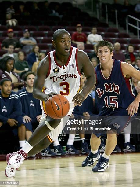 Lodrick Stewart of the University of Southern California Trojans drives to the basket against Damian Martin of the Loyola Marymount University Lions...