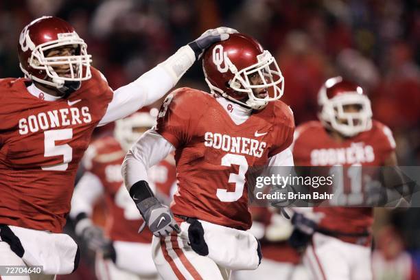 Defensive back Reggie Smith of the Oklahoma Sooners celebrates with Nic Harris after intercepting the Nebraska Cornhuskers late in the fourth quarter...