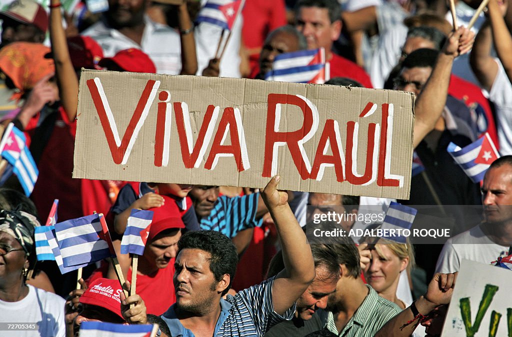 A Cuban holds a sign cheering acting Pre