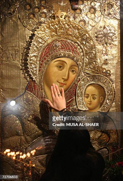 Palestinian Christian touches an icon of the Virgin Mary during a visit to the Church of Nativity, the alleged birthplace of Jesus Christ on the...