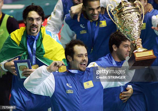 Brazil volleyball captain Ricardo Garcia shows off the trophy with teammates Gilberto Godoy Filho and Marcelo Elgarten during the victory lap after...