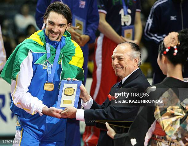 Brazilian volleyball star player Gilberto 'Giba' Godoy Filho is awarded the winner's plate for the Most Valuable Player by FIVB President Ruben...
