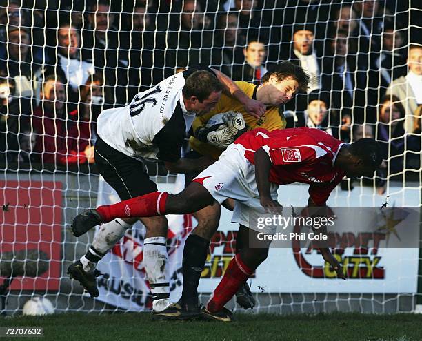Robert Matthews of Salisbury Town collides with Rune Pedersen, goal keeper of Nottingham Forest and Wes Morgan of Forest during the FA Cup 2nd Round...
