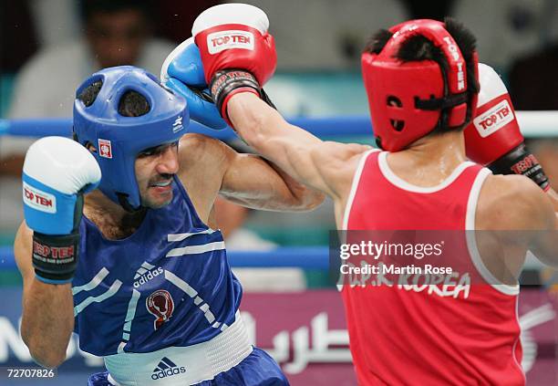 Abdullatef Sadiq of Qatar battles with Kim Song Guk of Democratic People's Republic of Korea during their feather 57kg Men's Boxing Qualification...