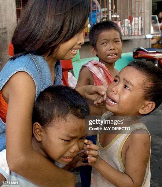 Teresa Quadro comforts her three brothers as they cry in the eastern Philippine village of Rawis, Legazpi after a rumour spread that a tsunami was...