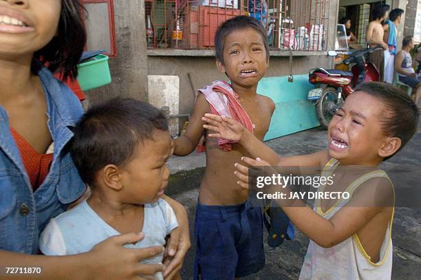 Teresa Quadro comforts her three brothers as they cry in the eastern Philippine village of Rawis, Legazpi after a rumour spread that a tsunami was...