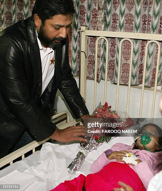 Pakistani cricket team captain Inzamam-ul-Haq leaves a bouquet of flowers at the bed side of a child patient during a visit to the Poly Clinic...