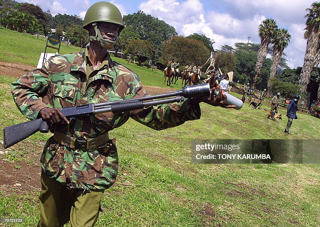 A Kenyan police officers loads a tear ga