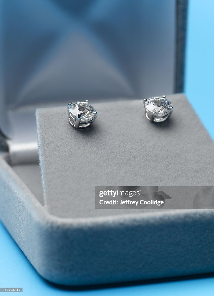 Two jeweled ear studs in display box, close-up