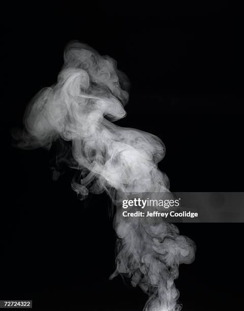 vapour rising against dark background - vapore foto e immagini stock