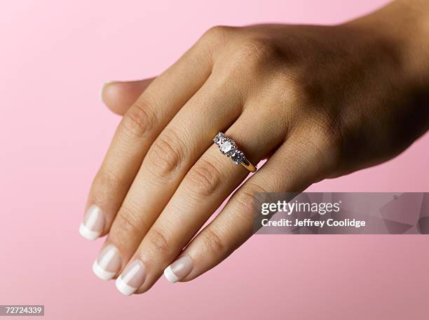 young woman wearing engagement ring, close up of hand (focus on ring) - anillo joya fotografías e imágenes de stock