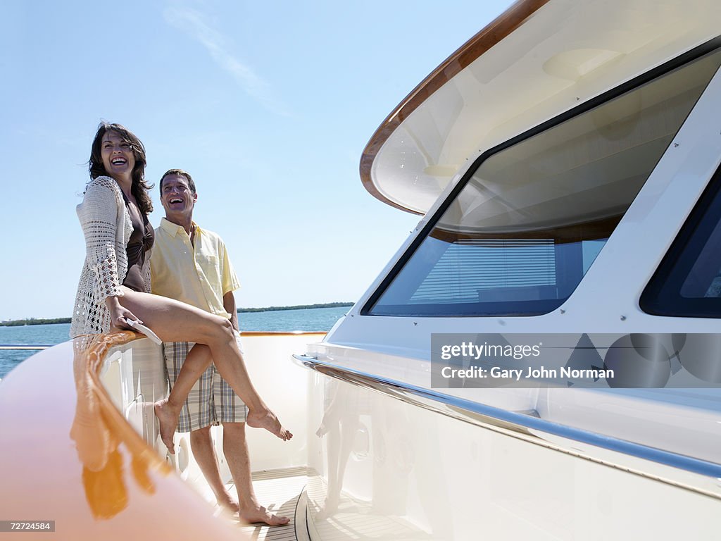 Couple smiling on deck of luxury yacht