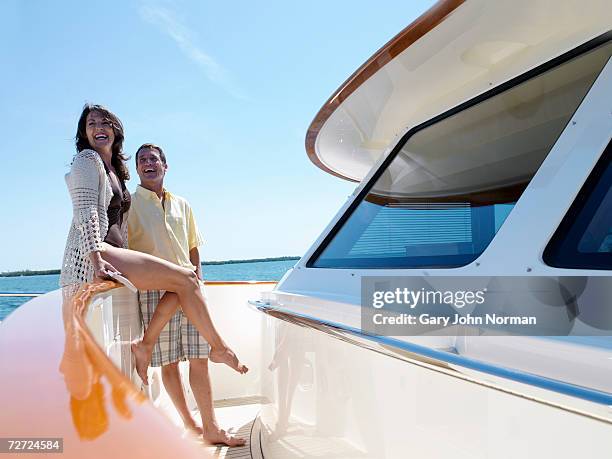 couple smiling on deck of luxury yacht - luxury yachts stock-fotos und bilder