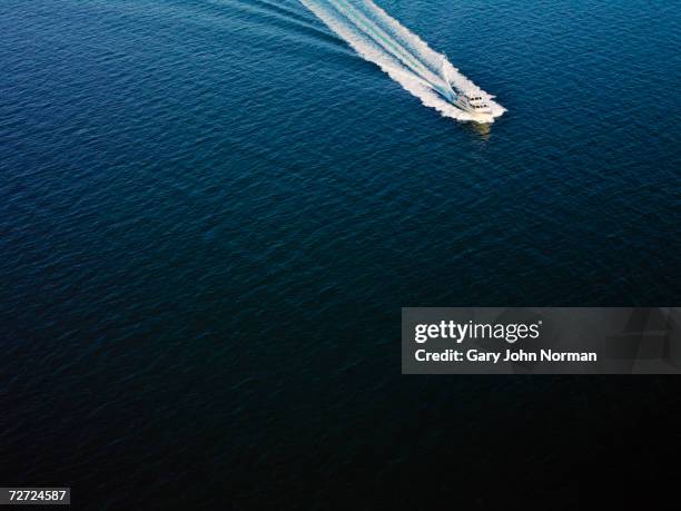 luxury yacht speeding over  sea leaving wake, aerial view - luxury yachts stockfoto's en -beelden