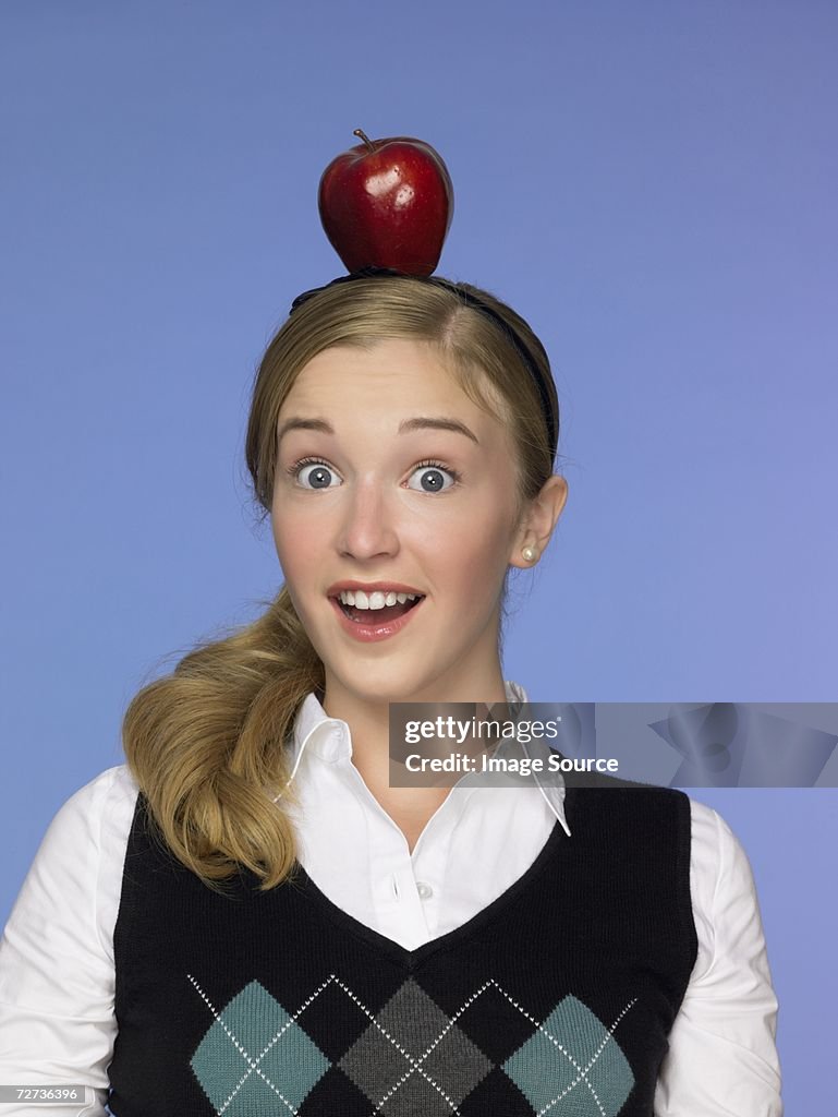 Girl balancing an apple on her head