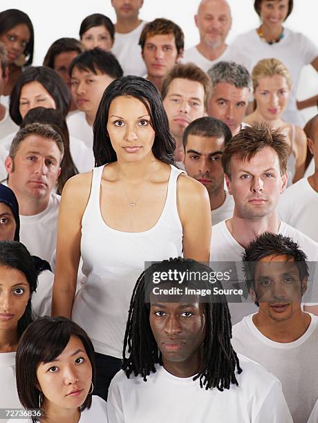 young woman standing out from the crowd - large group of people serious stock pictures, royalty-free photos & images