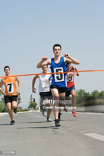 runners reaching finish line - marathon runner finish line stock pictures, royalty-free photos & images