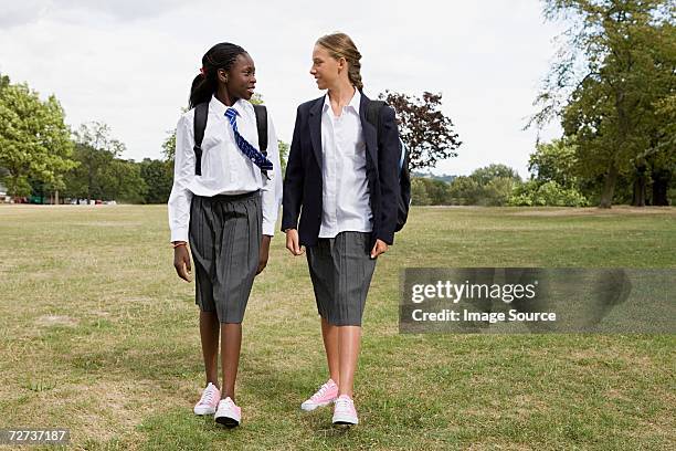 school friends walking - girl in school uniform stock pictures, royalty-free photos & images