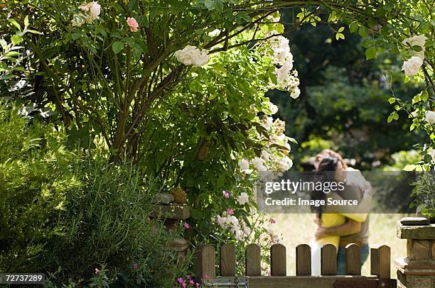couple hugging by garden gate - garden gate rose stock pictures, royalty-free photos & images