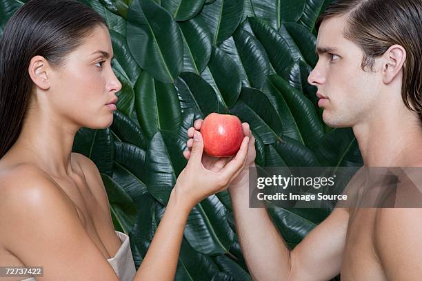 woman giving apple to man - temptation apple stock pictures, royalty-free photos & images