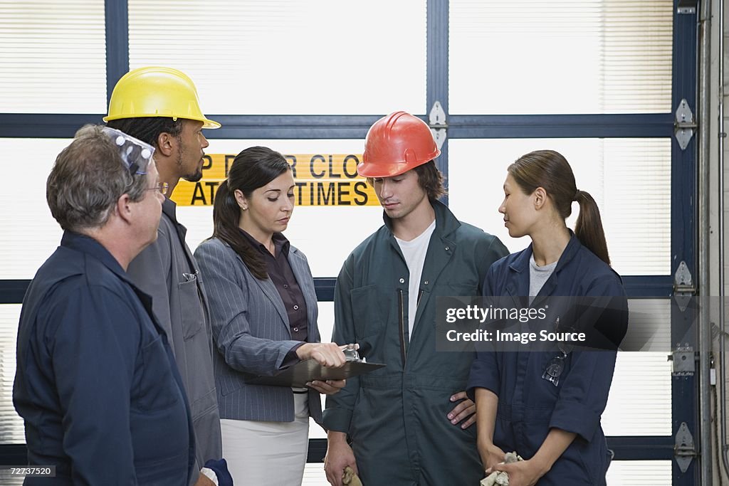 Factory workers talking to manager