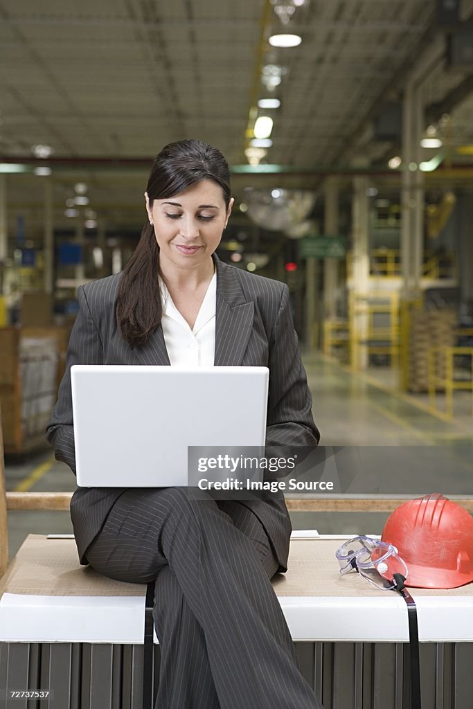 Woman using a laptop computer in factory