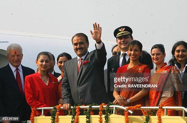 Union Minister of State for Civil Aviation, Praful Patel waves as US Ambassador to India, David Mullford and Air India hostesses with their new...