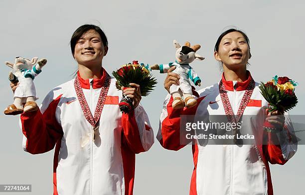 Tian Liang and Li Qin of Team China celenbrate on the podium after winning the Gold Medal in the Women's Double Sculls Rowing Competition during the...