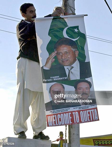 Worker hangs a poster ahead of visit by Pakistani President Pervez Musharraf in Quetta, the capital of southwestern province, 06 December 2006. This...