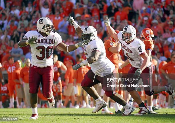 Yvan Banag , Stanley Doughty ans Kenny McKinley of the South Carolina Gamecocks celebrate on the field during the game against the Clemson Tigers at...