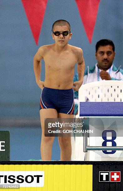 Ten-year-old Amer Ali of Iraq gets ready to compete in heat 2 of the men's 200m individual medley swimming event at the Hamad Aquatic Centre during...