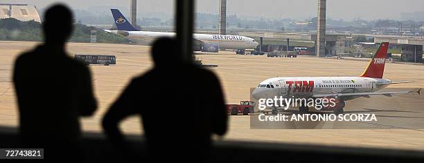 Rio de Janeiro, BRAZIL: Passengers observe a plane taxing at the Antonio Carlos Jobim's International airport, 06 December 2006, in Rio de Janeiro,...