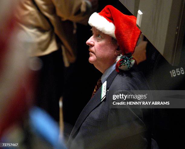 New York, UNITED STATES: : This 24 December 2002 file photo shows a trader on the floor of the New York Stock Exchange wearing a Santa Claus hat one...