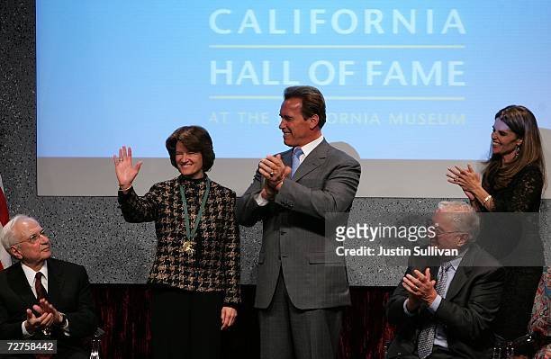 California Gov. Arnold Schwarzenegger applauds former astronaut Sally Ride after she was inducted into the California Hall of Fame December 6, 2006...
