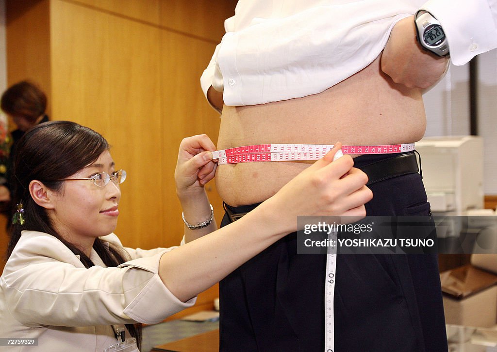 A government official measures waistline