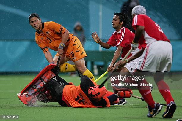 Leung Hong Wang Howard goalkeeper for Hong Kong, China dives at the feet of Chua Boon Huat of Malaysia during the Men's Field Hockey Preliminary...