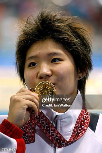 Tao Li of Singapore waves after receiving her gold medal for the Women's 50m Butterfly Final at the 15th Asian Games Doha 2006 at the Hamad Aquatic...