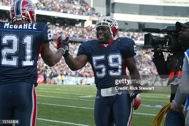 Linebacker London Fletcher-Baker of the Buffalo Bills receives congratulations from running back Willis McGahee during the game against the...