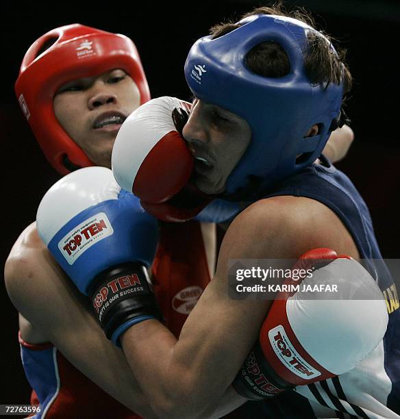 Galib Jafarov of Kazakistan fights with Anthony Marcial of Philppines during their 57kg boxing quarter-final bout at the 15th Asian Games in Doha in...