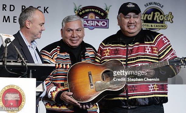 President and CEO of Hard Rock International Hamish Dodds presents a vintage Hank William guitar to Seminole tribal members Andrew Bowers and Max...