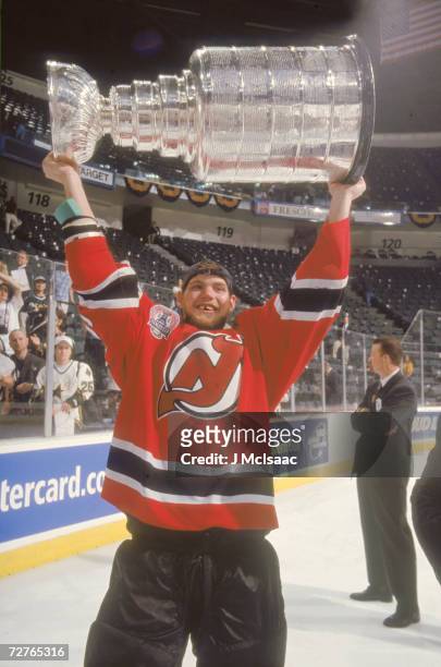 Gap-toothed Canadian ice hockey player Colin White of the New Jersey Devils raises the Stanley Cup in celebration after his teams' victory in the...