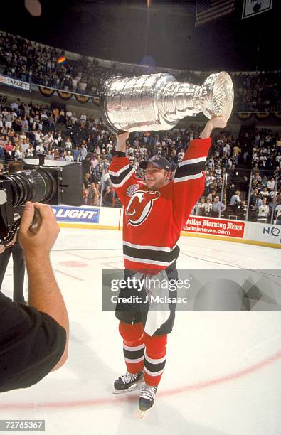 Canadian ice hockey player John Madden of the New Jersey Devils raises the Stanley Cup in celebration after his teams' victory in the finals, Dallas,...